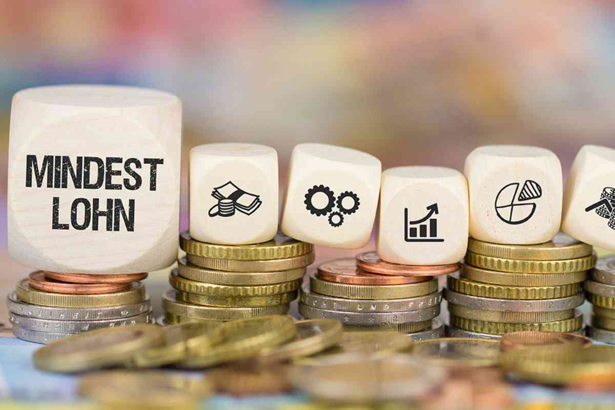 Münzen und Würfel mit Symbolen und Beschriftung Mindestlohn