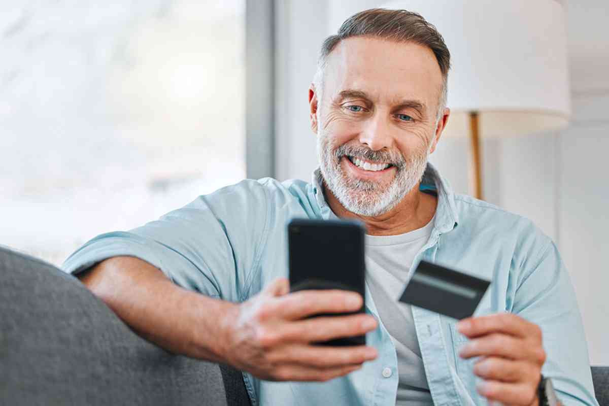 Mann mit Smartphone und Kredikarte