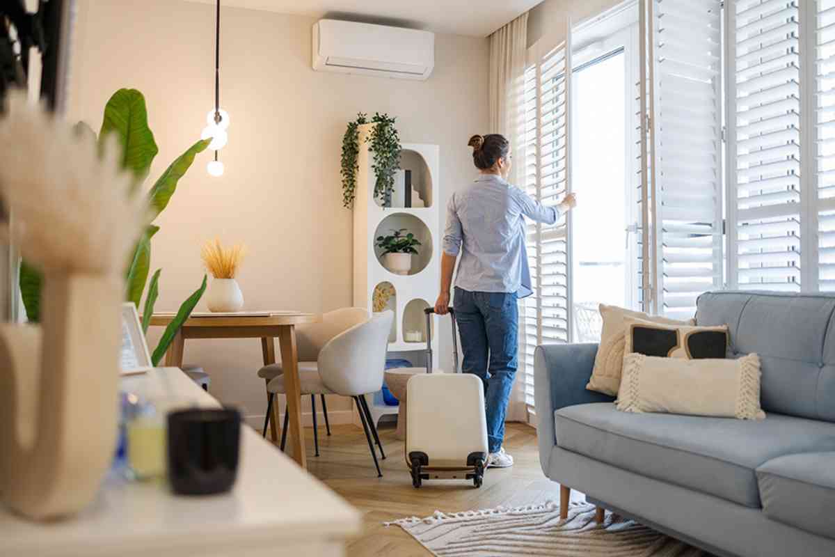 Frau öffnet Fenster in Wohnung