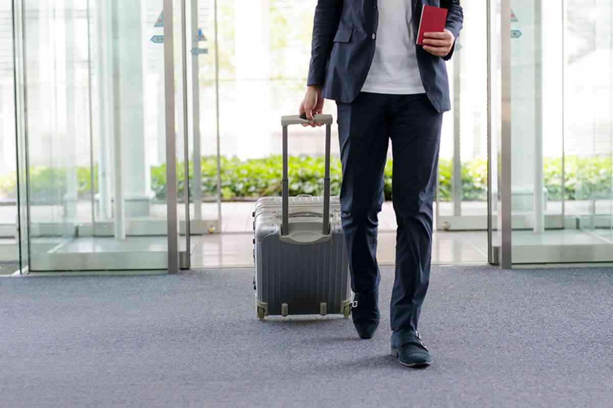 Mann mit Koffer am Flughafen